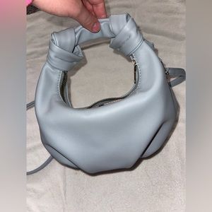 This is a sky blue crossbody bag, with a pink leopard print on the inside !
